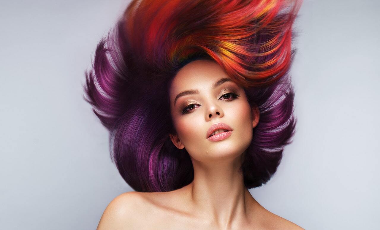 Bella donna con capelli multicolore, trucco e acconciatura creativi